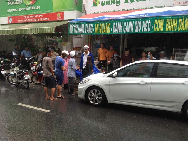 Anh Phương (mặc &aacute;o sơ mi trắng) đứng giữa mưa gi&oacute; bắt t&agrave;i xế &ocirc; t&ocirc; g&acirc;y tai nạn giao th&ocirc;ng phải xuống xe xin lỗi