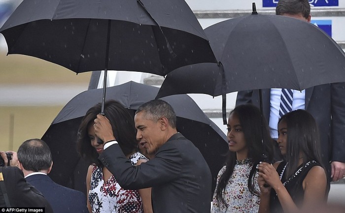 Ngoài sự hài hước, ông Obama còn được biết đến là người chồng rất thương yêu vợ con. Ông che ô cho vợ trong một cơn mưa nặng hạt.
