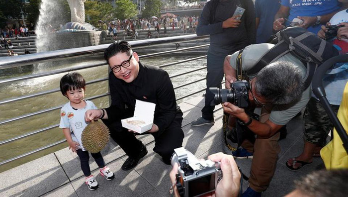 kim-jung-un-tuoi-cuoi-khoe-sau-rieng-tren-duong-pho-singapore-khien-nguoi-dan-xon-xao