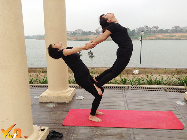 Tư thế yoga đôi đẹp mắt do chị Bích Hà 55 tuổi và chi Kim Oanh 36 tuổi thực hiện. 