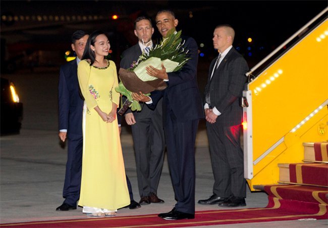 Tổng thống Barack Obama vui vẻ nhận bó hoa tươi từ đoàn tiếp đón của Việt Nam trao tặng (Ảnh Reuters)