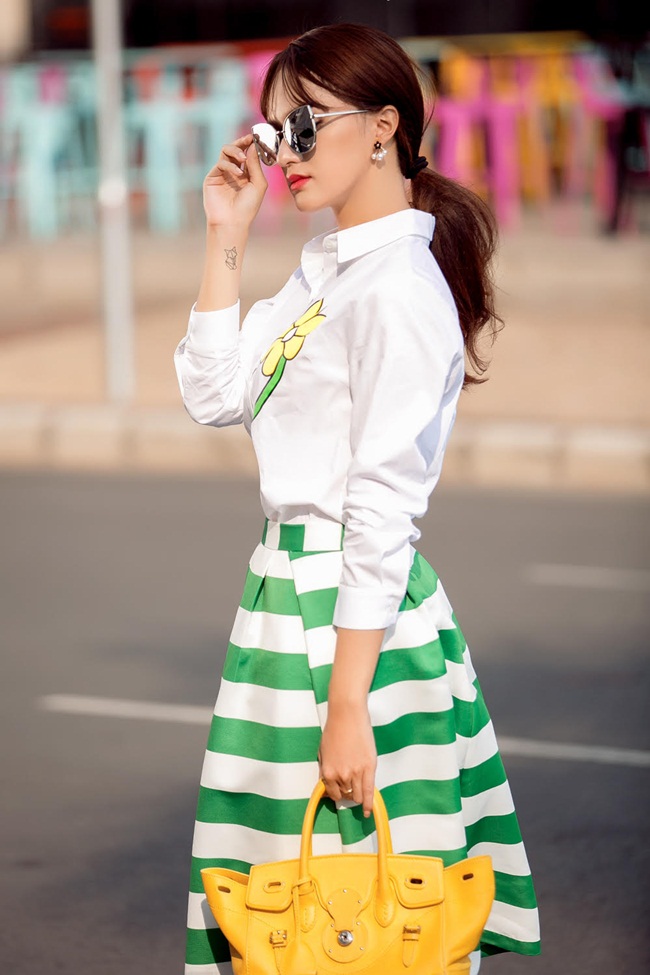 Hương Giang idol luôn đa dạng trong phong cách, có khi cô  xuất hiện thanh lịch và năng động trong chiếc váy sọc ngang xanh trắng đi cùng áo sơ mi trắng với điểm nhấn là bông hoa trên ngực. 