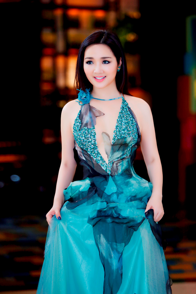 Giáng My chọn hai chiếc váy của NTK Hoàng Hải, một chiếc màu xanh vẽ hoa bằng vải voan nhẹ nhàng bay bổng để xuất hiện trên sóng truyền hình. 