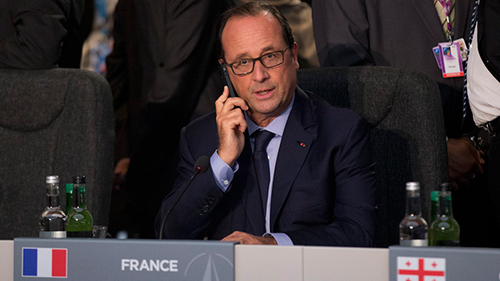 Tổng thống Ph&aacute;p Francois Hollande nghe điện thoại tại một hội nghị của NATO năm ngo&aacute;i