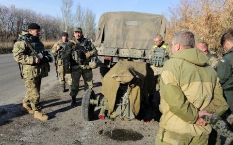 Binh sĩ Ukraine đứng gần một khẩu ph&aacute;o chuẩn bị được r&uacute;t ra khỏi miền Đ&ocirc;ng