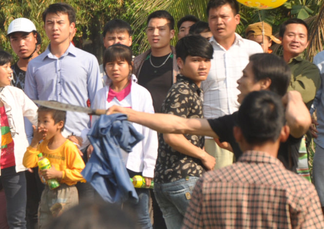 M&ocirc;̣t thanh ni&ecirc;n cầm theo dao bầu chạy v&agrave;o đ&aacute;m đ&ocirc;ng để la hét đe dọa, rượt đuổi các đ&ocirc;́i tượng khác trong lễ hội