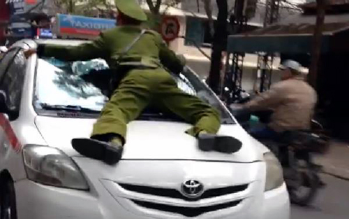 H&igrave;nh ảnh chiến sĩ c&ocirc;ng an phường bị t&agrave;i xế l&aacute;i taxi h&atilde;ng Group hất l&ecirc;n nắp ca p&ocirc;