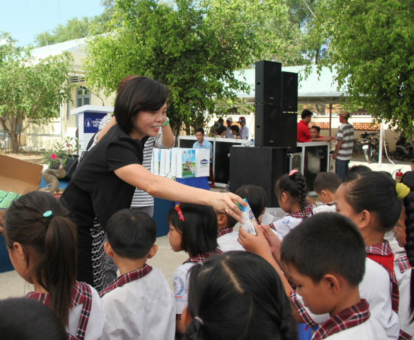 B&agrave; B&ugrave;i Thị Hương - Gi&aacute;m đốc Đối ngoại Vinamilk trao sữa cho trẻ em
