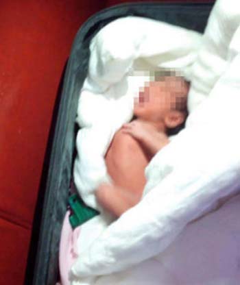 B&eacute; g&aacute;i sơ sinh người Trung Quốc bị cha ruột giấu dưới đống quần &aacute;o nh&eacute;t trong vali