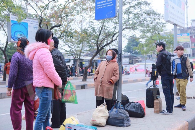 Nhiều người &ldquo;vật v&atilde;&rdquo; đứng chờ xe bus. Ảnh: VietnamPlus