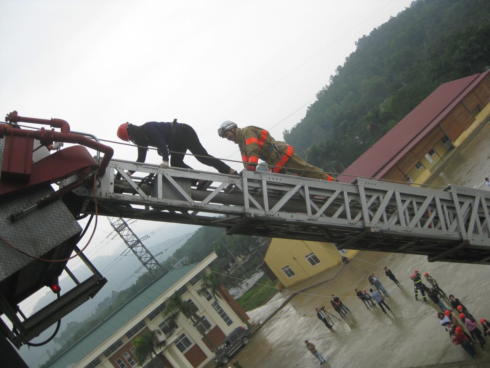C&aacute;c chuy&ecirc;n gia đ&agrave;o tạo đang hướng dẫn c&aacute;c học vi&ecirc;n tho&aacute;t hiểm bằng thang...