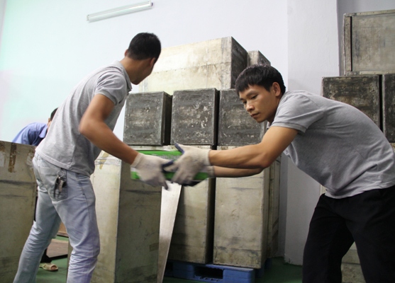 Vải được chuyển vào thùng để chuyển lên dây chuyền chiếu xạ