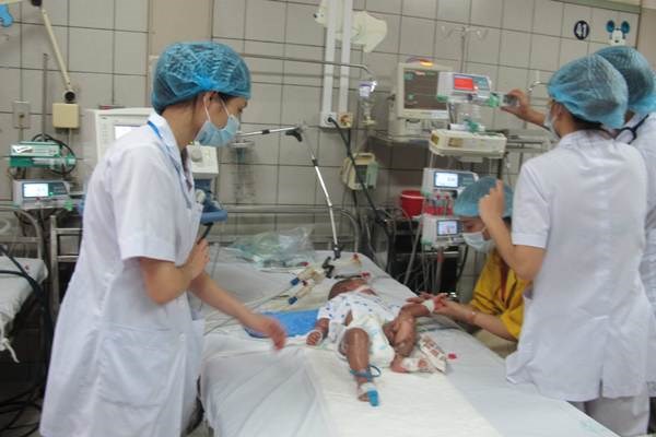 Một bệnh nhân nhi mắc sởi trong tình trạng nguy hiểm đang được các nữ y tá, hộ lý theo dõi. 