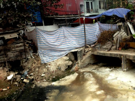 Mứt cũng được phơi ngay cạnh cống nước thải với sự ngăn cách là 1 tấm bạt để khuất mắt trông coi