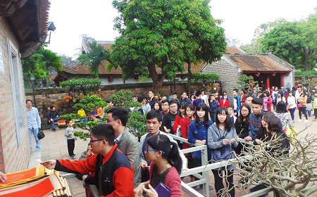 Xếp hàng mua giấy, nhận số thứ tự để chuẩn bị bước sang khu vực các ông đồ viết chữ. Ảnh: Dân trí