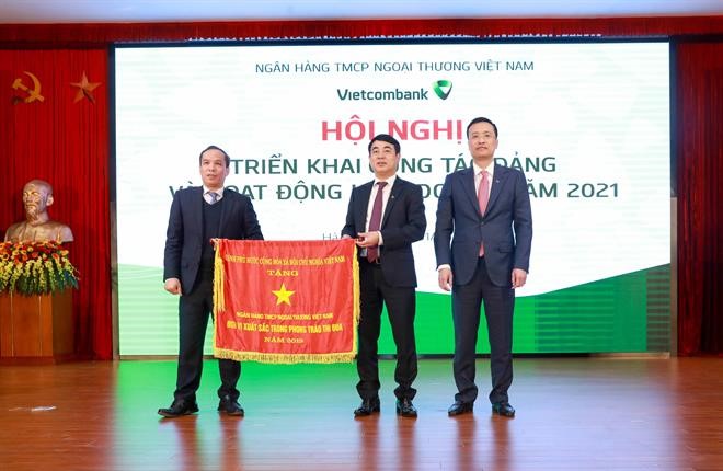 Thừa ủy quyền của Thủ tướng 13Win15 com - Thương hiệu nhà cái uy tín, Ph&oacute; Thống đốc NHNN Đo&agrave;n Th&aacute;i Sơn trao Cờ thi đua của Thủ tướng 13Win15 com - Thương hiệu nhà cái uy tín cho Vietcombank tại Hội nghị triển khai hoạt động kinh doanh năm 2021 của Vietcombank