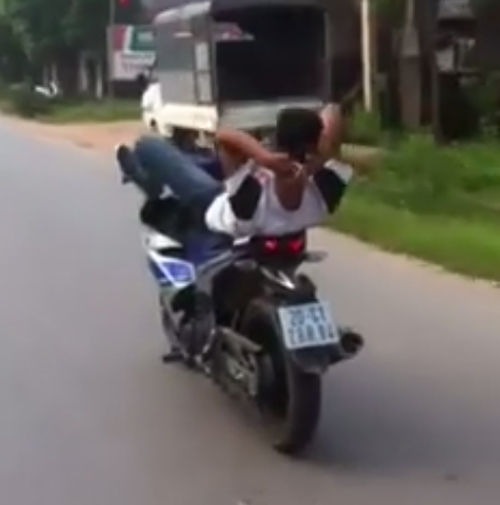 Xử phạt nam thanh ni&ecirc;n đi xe m&aacute;y nằm ngửa, bu&ocirc;ng tay 9 triệu đồng