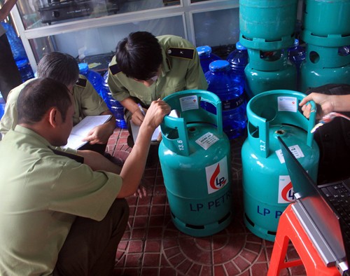 Quản l&yacute; thị trường kiểm tra c&aacute;c b&igrave;nh gas của C&ocirc;ng ty Long Phụng - Ảnh: Phạm Anh 