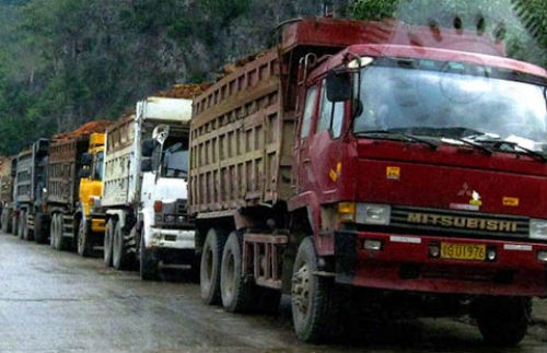 Xe chở quặng sắt qua bi&ecirc;n giới (Ảnh SGTT).